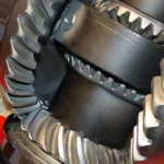 Mechanic and car owner discussing transmission noise beside a car in a repair bay