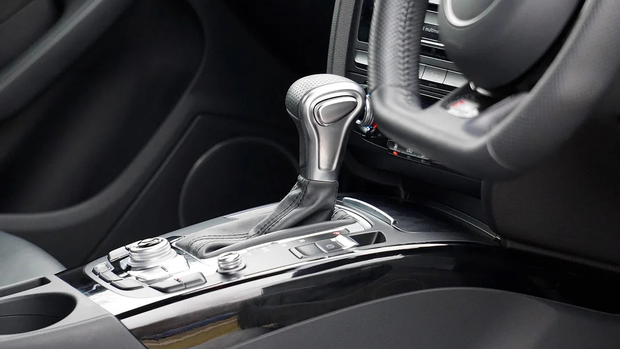 Driver beside a sedan with the hood open, concerned about an automatic transmission issue