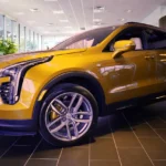 Mechanic checks an AWD warning light on a crossover SUV with hood open in a bright garage.