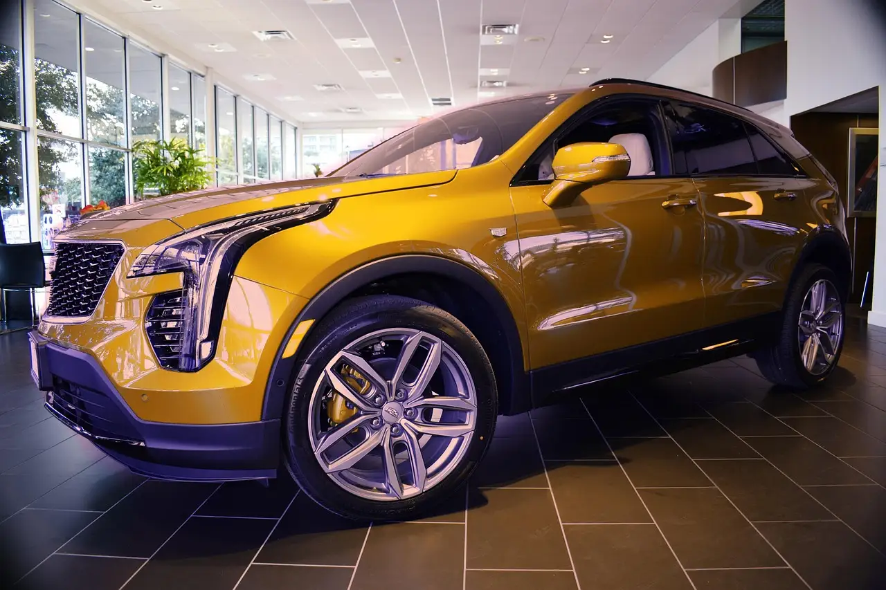 Mechanic checks an AWD warning light on a crossover SUV with hood open in a bright garage.